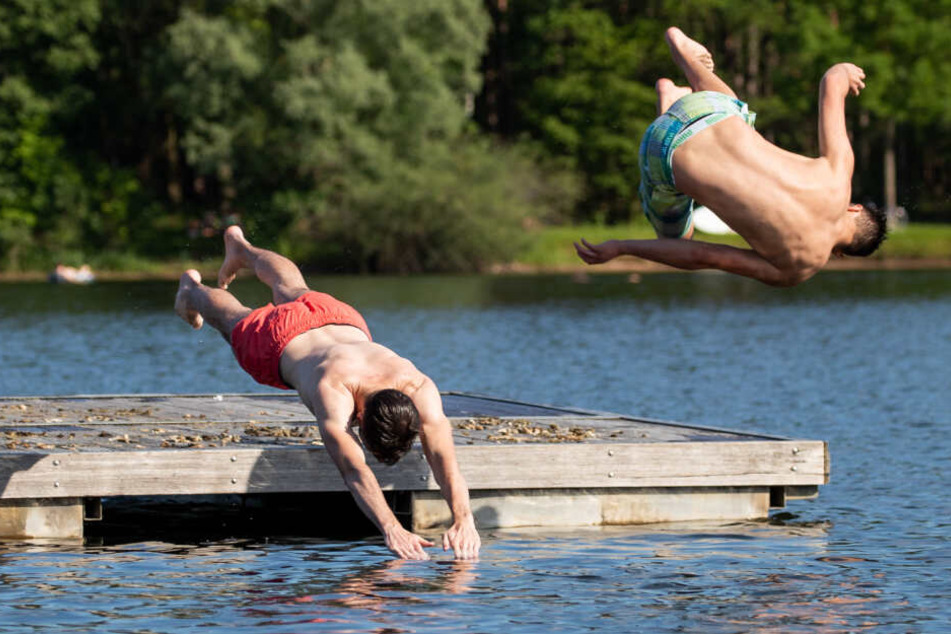 Jugendliche springen von einer Schwimminsel in den Rothsee.