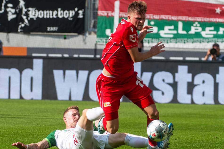 Unions Marius Bülter (oben) setzt sich gegen Augsburgs André Hahn durch.