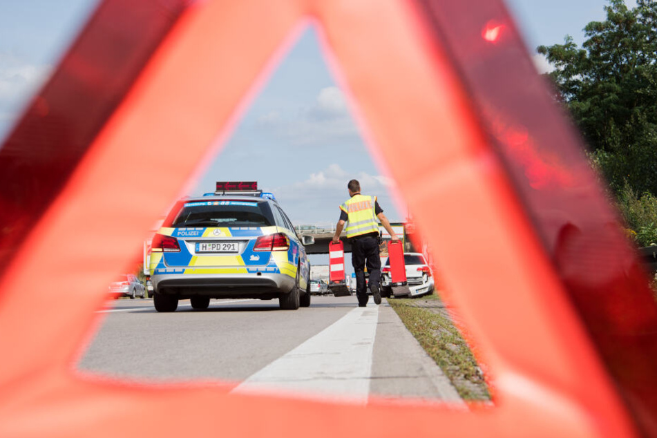 Ein Beamter der Autobahnpolizei sichert eine Unfallstelle. (Symbolbild)