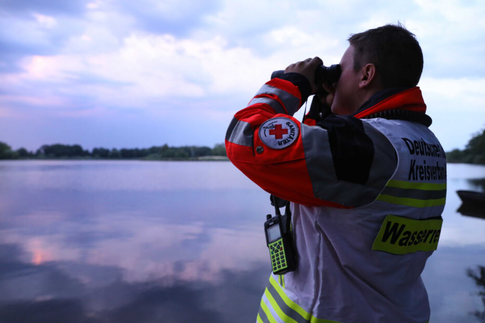 Ein Wasserretter vom Deutschen Roten Kreuz sucht den Dippelsdorfer Teich nach einem Vermissten ab. Die Ehrenamtlichen investieren viele Stunden ihrer Freizeit zum Wohl der Allgemeinheit.