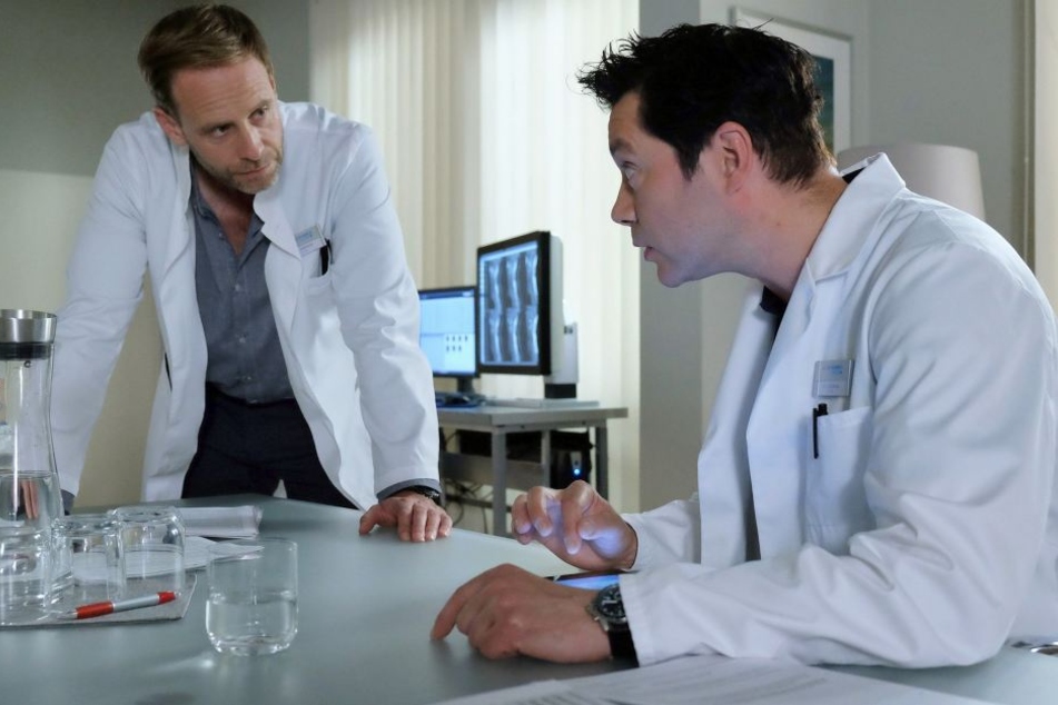 Chefarzt Dr. Kai Hoffmann (l.) ist mit der Arbeit und Verfassung des leitenden Oberarztes Dr. Philipp Brentano nicht zufrieden. Er schlägt ihm eine dreimonatige Auszeit vor.
