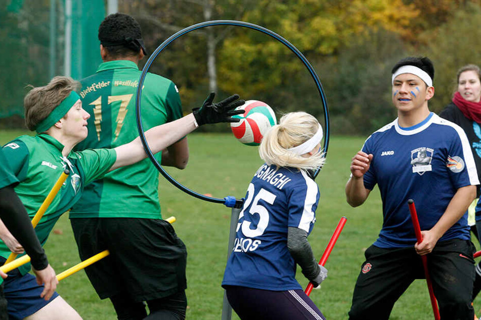 Spieler der Bonner Rheinos (blau) spielen gegen die Bielefelder Basilisken (grün).