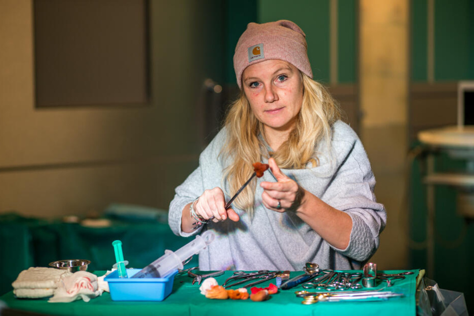 Sarah Zeising prüft in der OP-Kulisse die bereitliegenden chirurgischen Instrumente für die nächste Filmszene.