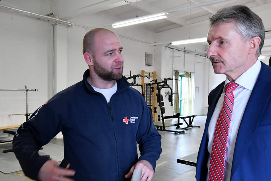 Brandenburgs Innenminister Karl-Heinz Schröter (SPD) unterhält sich mit Fitnesstrainer Rene Schenk, der in der Einrichtung arbeitet.