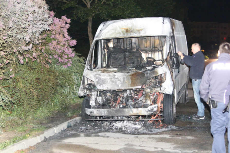 Polizisten bei der Spurensuche und Dokumentation eines angezündeten Transporters.