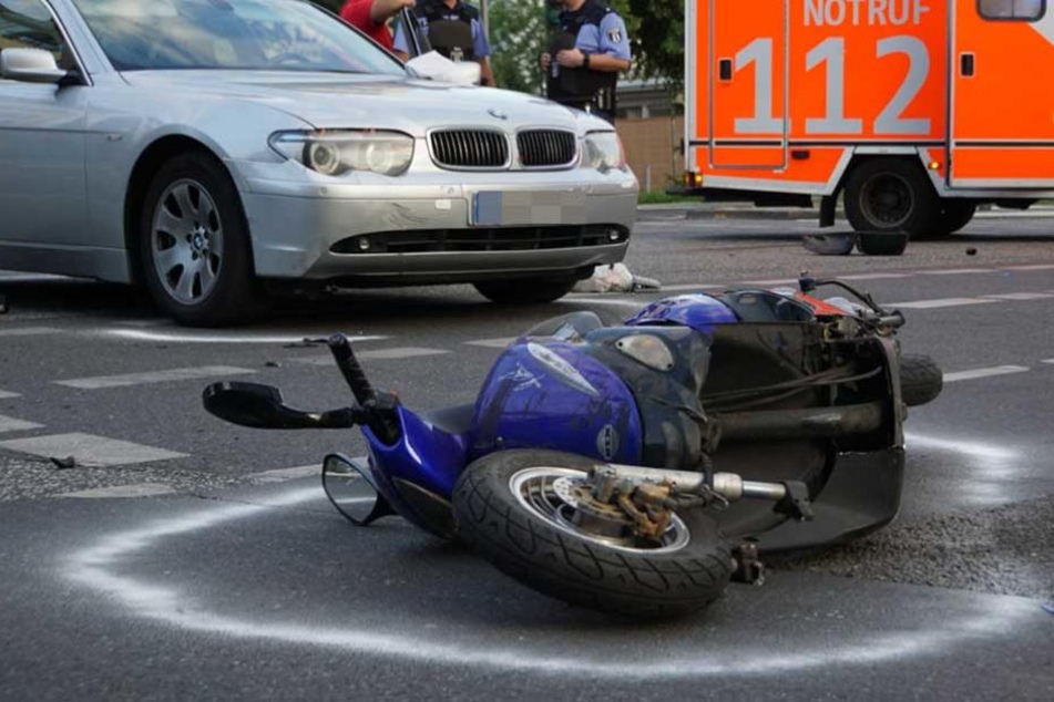 Der völlig demolierte Motorroller liegt auf der Straße.