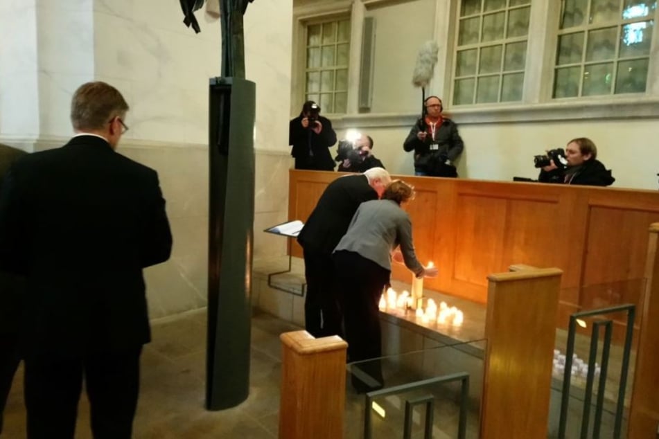 Bundespräsident Frank-Walter Steinmeier und seine Frau Elke zünden in der Frauenkirche eine Kerze an.