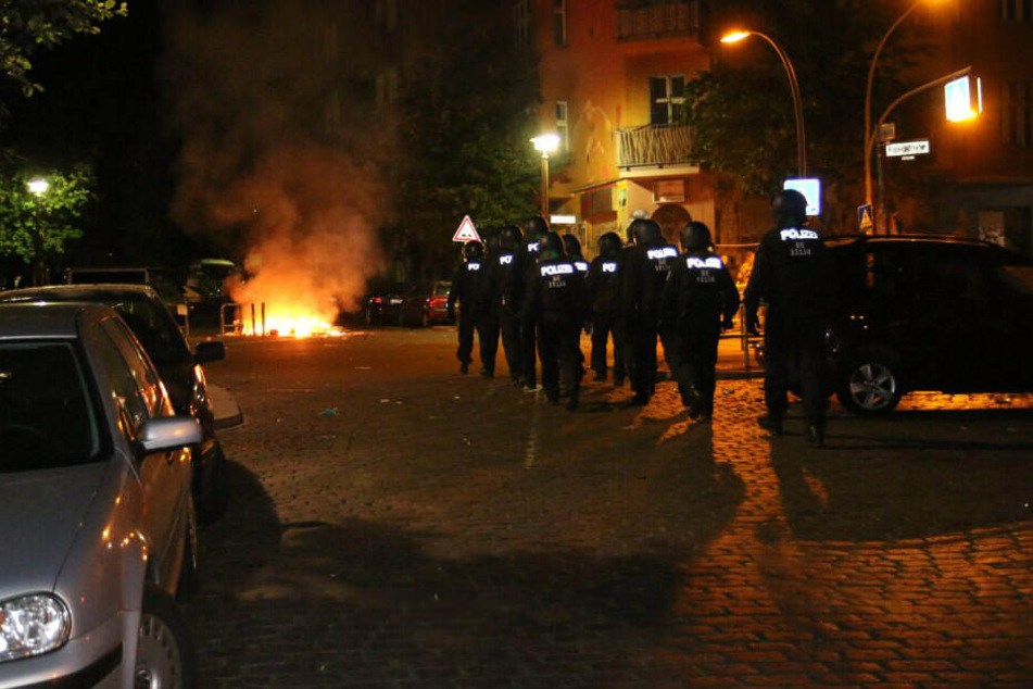 Polizisten nähern sich den brennenden Barrikaden