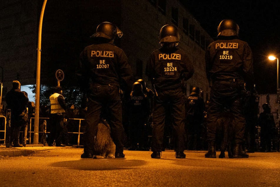 Polizeibeamte mit Hunden stehen unweit der Rigaer Straße Demonstranten gegenüber, die gegen eine Veranstaltung der rechts gerichteten Vereinigung Pegida aus München protestierten.