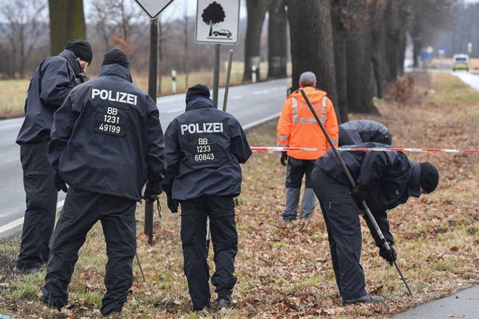 Polizisten suchen am Tatort nach Spuren.