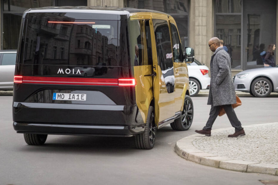 Ein Moia-Elektrobus sammelt einen Passagier in der Innenstadt ein.