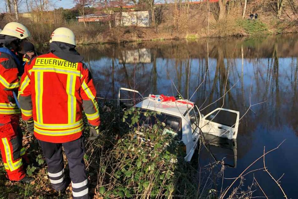 Feuerwehrleute stehen vor dem Regenwasserbecken in Neu Wulmstorf.