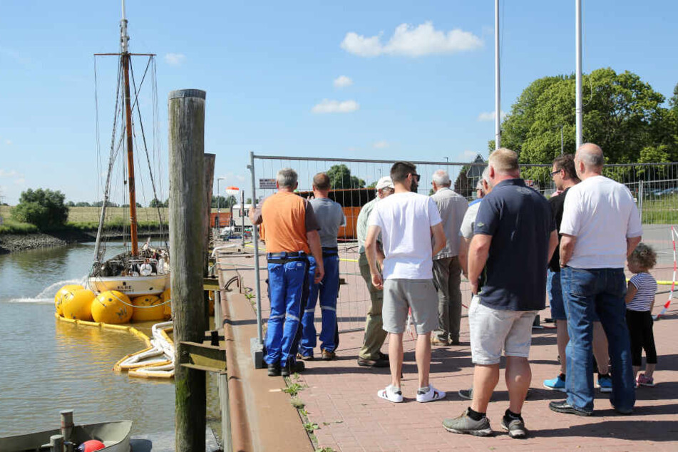 Schaulustige verfolgen die Arbeiten auf dem Segelschiff "No. 5 Elbe", das am Pier in Stadersand liegt. In der letzten Nacht wurde das Schiff mittels Luftkissen gehoben.