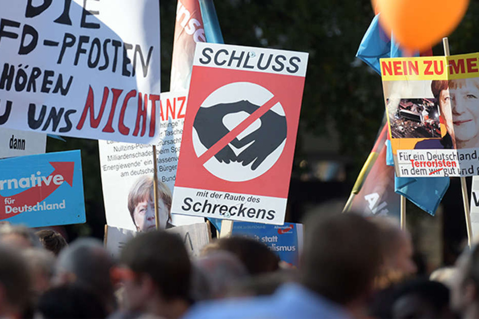 Ostdeutschland ist gespalten: "Nein zu Merkel", "Die AFD-Pfosten gehören nicht zu uns" oder "Schluss mit der Raute des Schreckens" sind auf einigen Plakaten zu lesen.