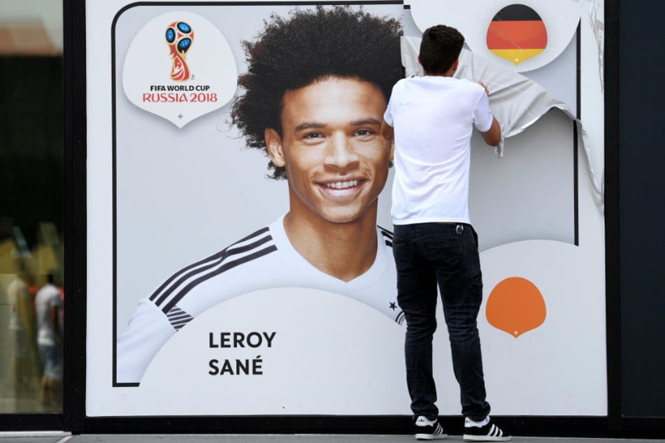 Ein Bild mit Symbolcharakter: Ein Mitarbeiter des Fußballmuseums zieht eine Folie mit dem Porträt von Leroy Sané ab.