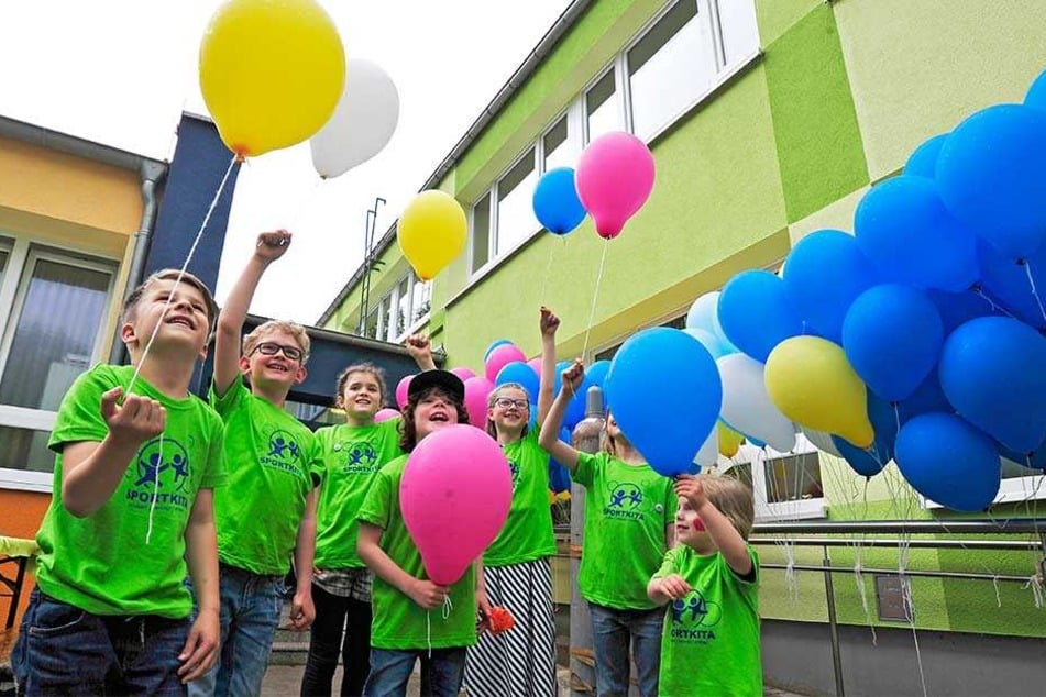 Die Kinder der Sportkita Eschenweg bereiten Luftballons zum Aufsteigen vor,
an denen sie ihre Wünsche für die Zukunft angeheftet haben.