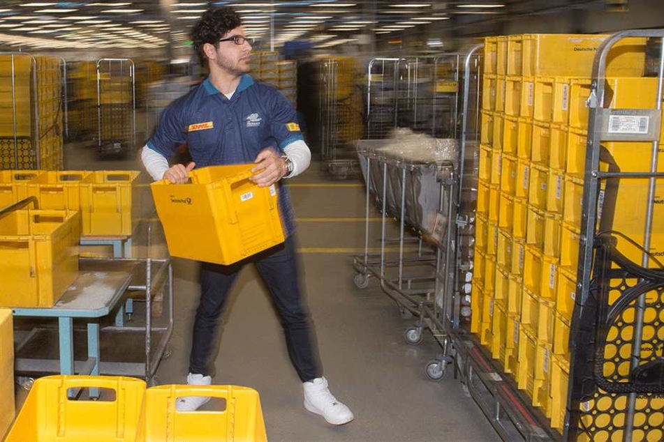 Der Flüchtling Anas Almalla stapelt im Briefzentrum der Deutschen Post Postkisten.