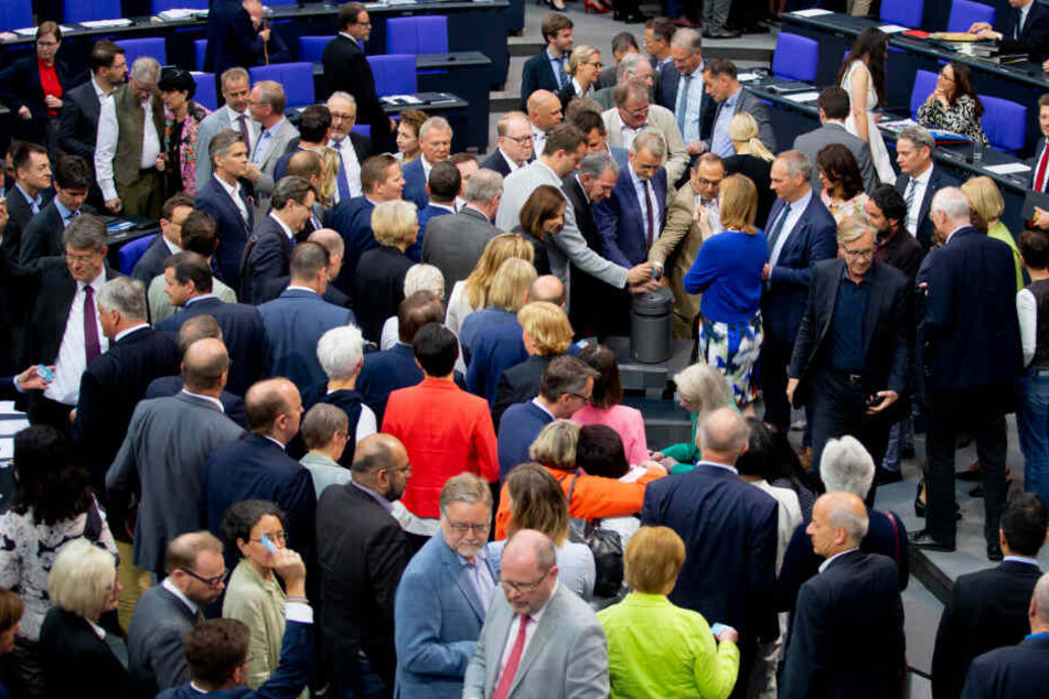 Mitglieder des Deutschen Bundestages stimmen im Plenum im Bundestag an einer Urne zum Asyl- und Aufenthaltsrecht ab.