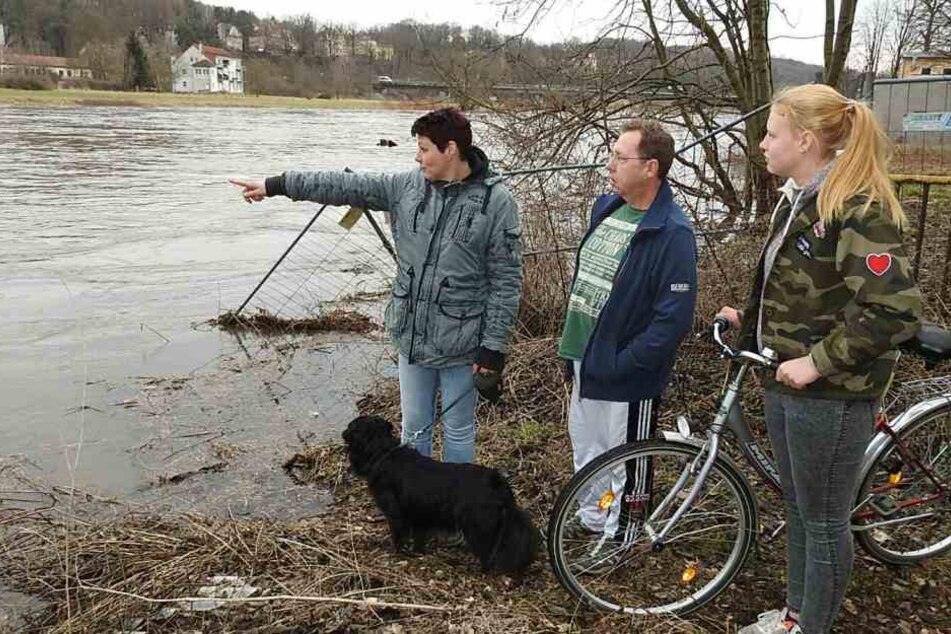 Familie Müller schaut besorgt auf den vollen Fluss in Grimma.