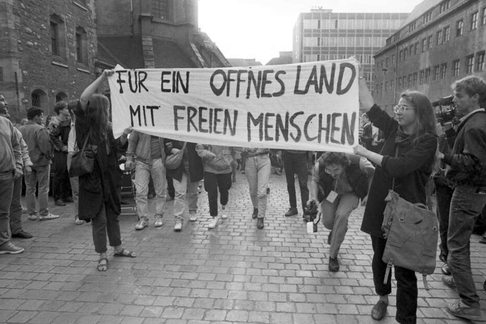 "FÜR EIN OFFNES LAND MIT FREIEN MENSCHEN" - Katrin Hattenhauer (rechts im Bild) entfaltete das Transparent am 4. September 1989 gemeinsam mit Gesine Oltmanns auf dem Nikolaikirchhof.