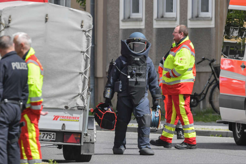 Ein Sprengstoffexperte geht in Schutzausrüstung über die gesperrte Amtstraße.