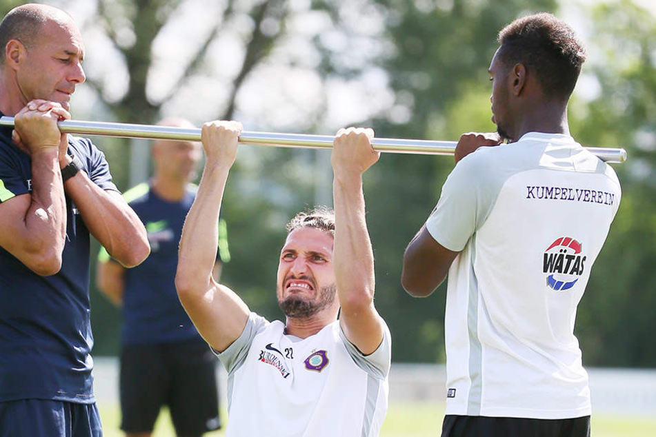 Auch Kraftübungen gehören dazu! Fabio Kaufmann macht Klimmzüge, Fitness-Coach Werner Schoupa (l.) und Moise Ngwisani halten die Stange.
