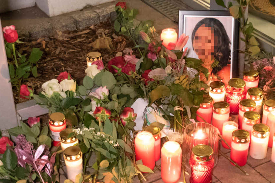 Trauernde haben Blumen neben ein Foto des Opfers gelegt.