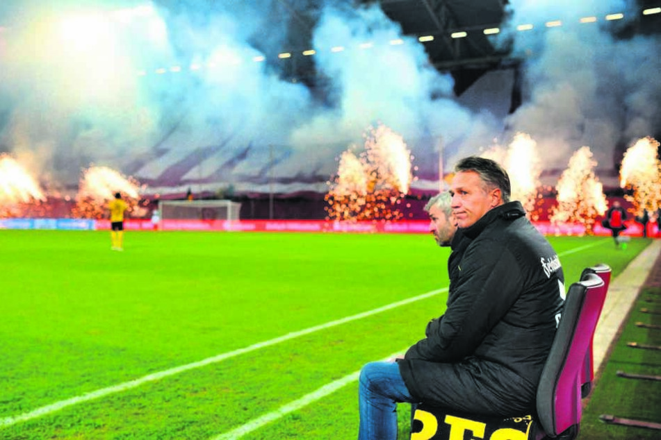 Uwe Neuhaus auf der Trainerbank vor dem Heimspiel gegen den 1. FC Kaiserslautern. "Hier im Osten leben die Menschen den Fußball", sagt er. Die Choreo im Hintergrund beweist das.
