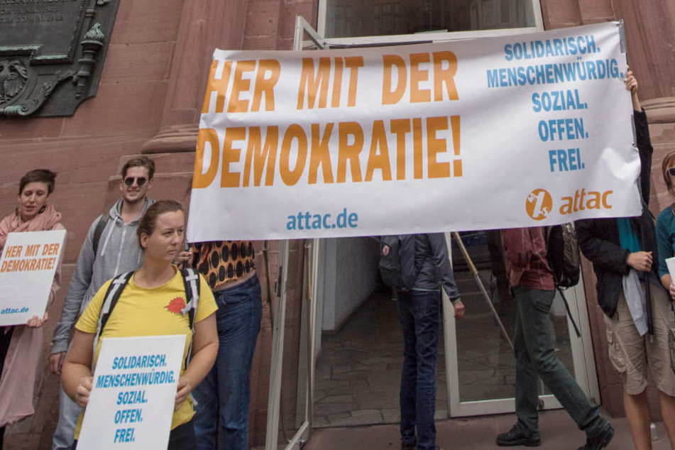 "Attac"-Aktivisten stehen vor der Paulskirche in Frankfurt.