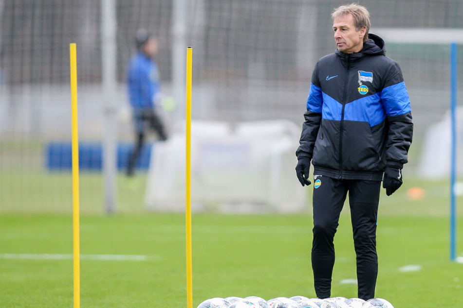 Herthas Trainer Jürgen Klinsmann steht hinter Fußbällen auf dem Trainingsplatz.