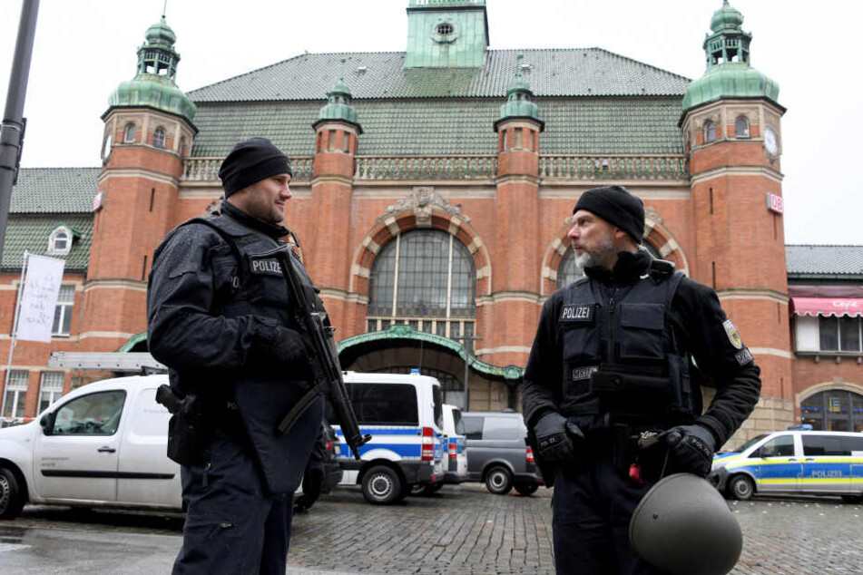 Polizeibeamte stehen vor dem Hauptbahnhof in Lübeck, der nach der Bombendrohung evakuiert werden musste.