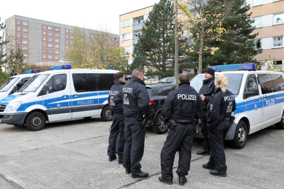 Polizisten stehen vor den Plattenbauten in Schwerin. 