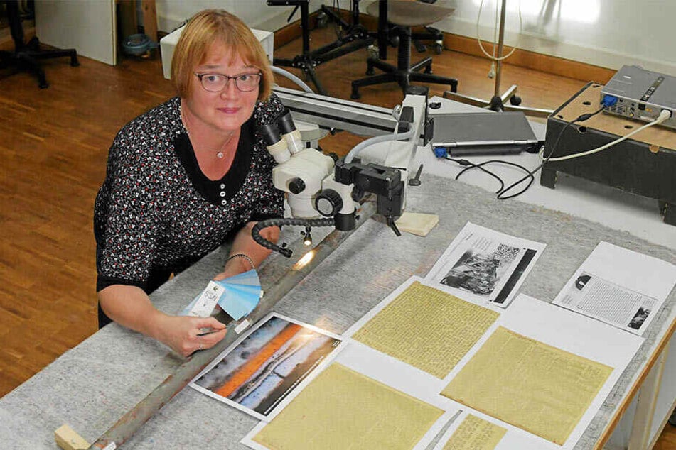 Metallrestauratorin Annegret Michel untersucht am Mikroskop einen historischen Pfeiler der Turmbekrönung.