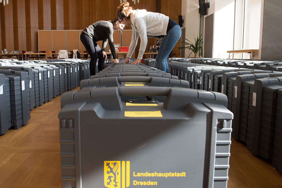 Zwei Stadt-Mitarbeiterinnen bereiten im Dresdner Rathaus die Wahlkoffer mit den Stimmzetteln vor.