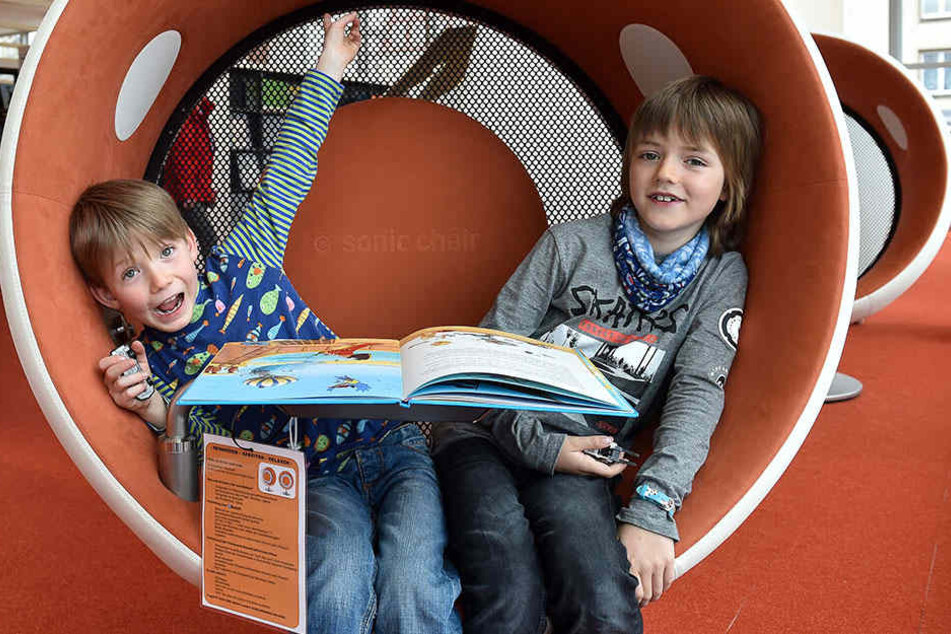 Leo (6, li.) und Toni (9) lümmeln vergnügt in einem Audiosessel. 2017 wurden bei den Städtischen Bibliotheken Dresden insgesamt knapp 970.000 Kinderbücher ausgeliehen.