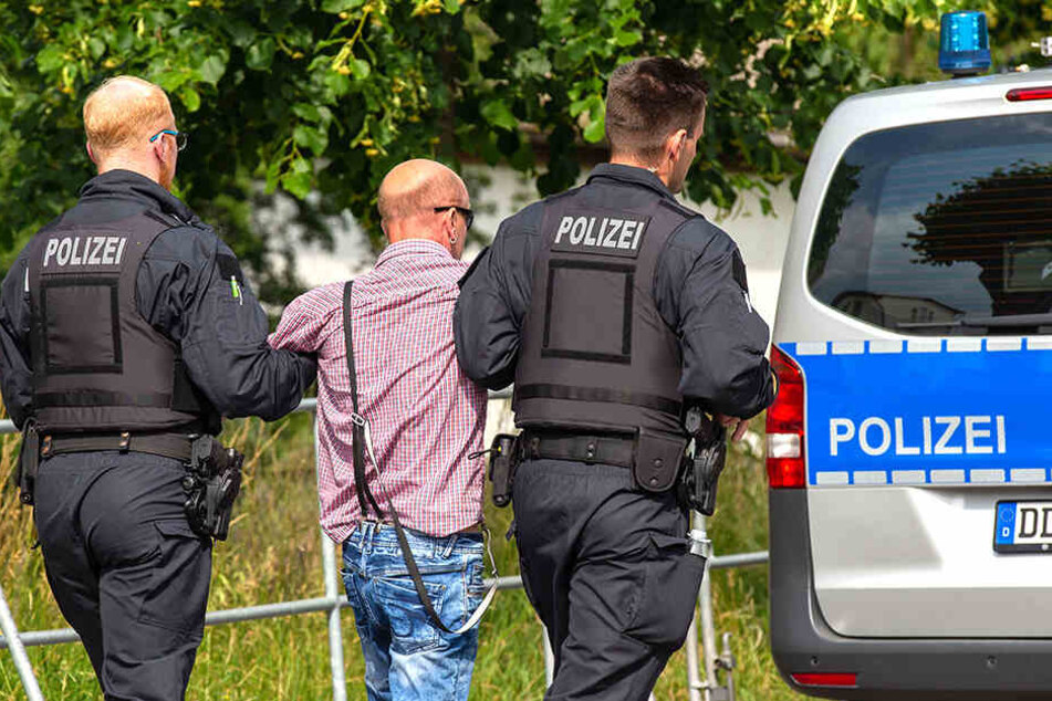 Ein Teilnehmer des "Schild und Schwert"-Festivals wird nach einer Attacke auf Journalisten abgeführt.