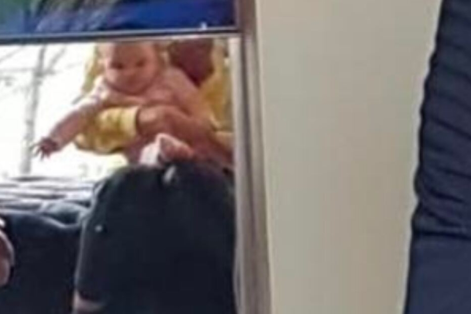 ... denn im Spiegelbild links von ihm, ist das Gesicht seiner kleinen Tochter, die auf dem Schoss seiner Freundin Julia sitzt, zu erkennen.
