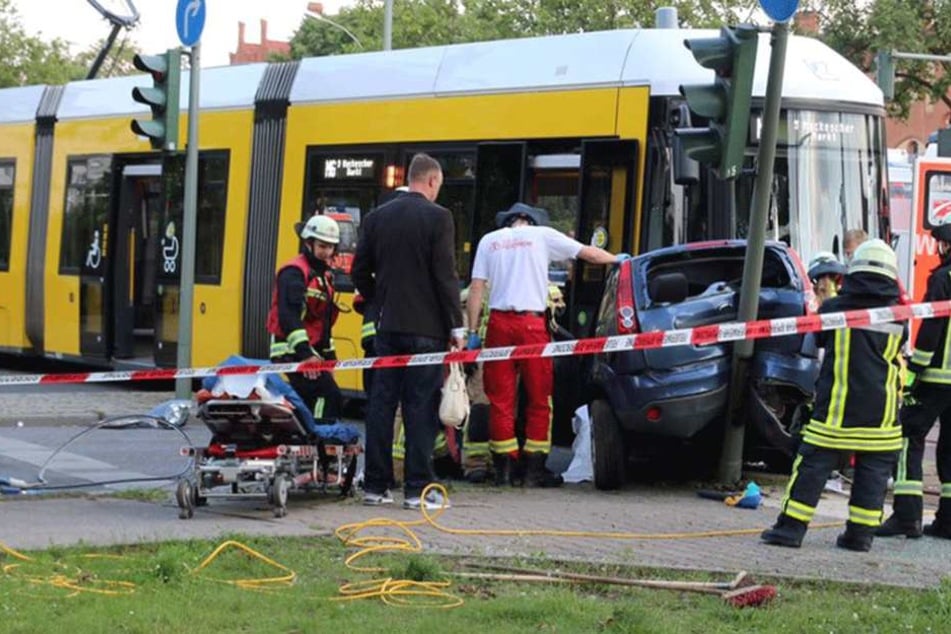 Rettungskräfte sind damit beschäftigt, die Verletzten aus dem Auto zu bergen.