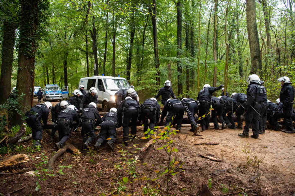 Polizisten mussten bereits am Sonntag Bäume von Waldwegen räumen, die Aktivisten dort zuvor hingetragen hatten.