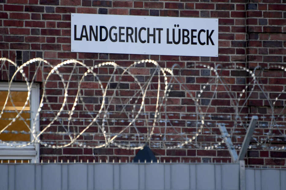 Das Schild "Landgericht Lübeck" ist hinter Stacheldraht am Gerichtsstandort zu sehen.