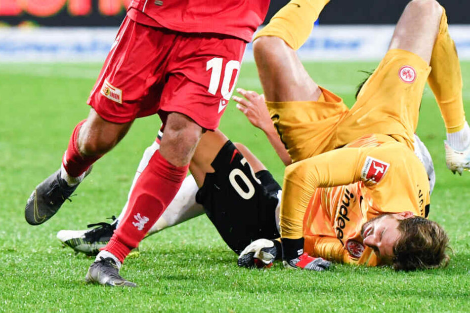 Das Foto zeigt den Moment der Verletzung: Kevin Trapp (r), Makoto Hasebe (hinten) und Sebastian Andersson von Union Berlin waren in einem Zweikampf aufeinander geprallt.