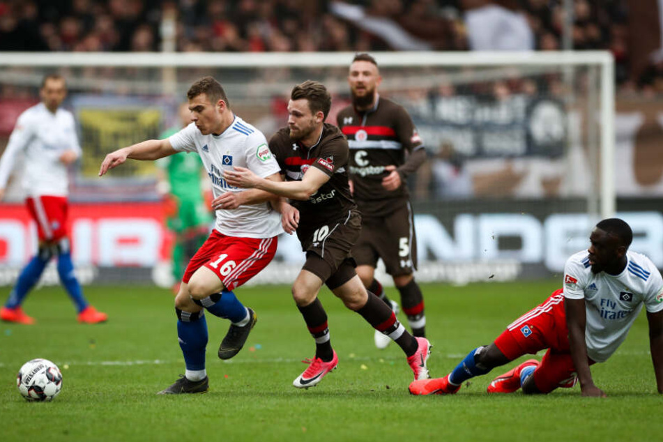 St. Paulis Christopher Buchtmann (M) und Hamburgs Vasilije Janjicic (l) kämpfen um den Ball.