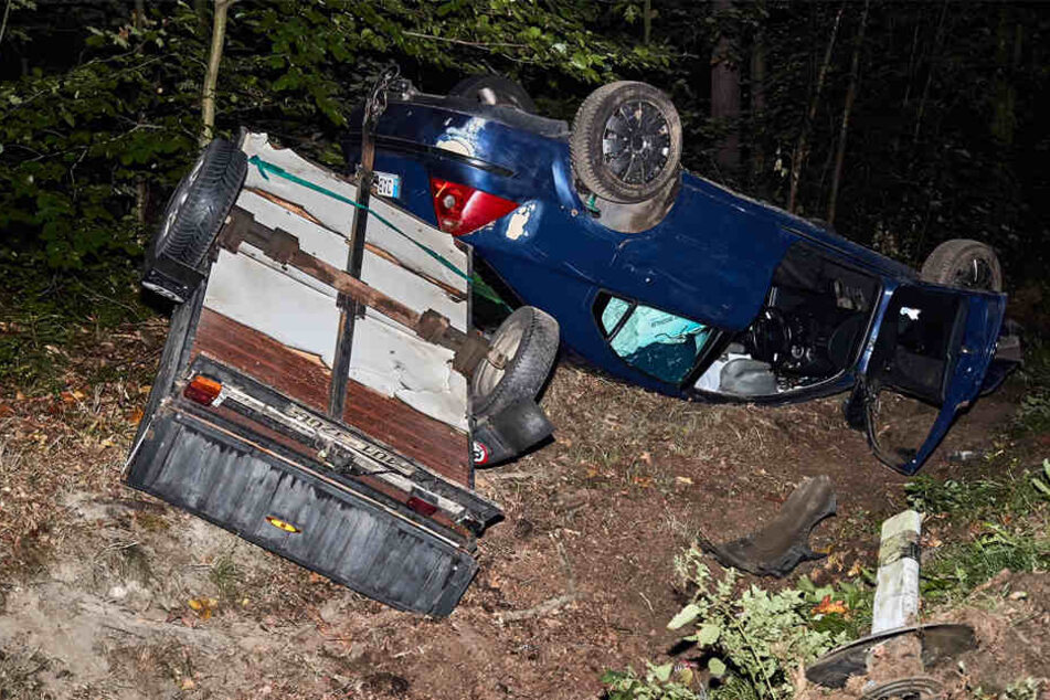 Auto und Anhänger blieben auf dem Dach im Straßengraben liegen.
