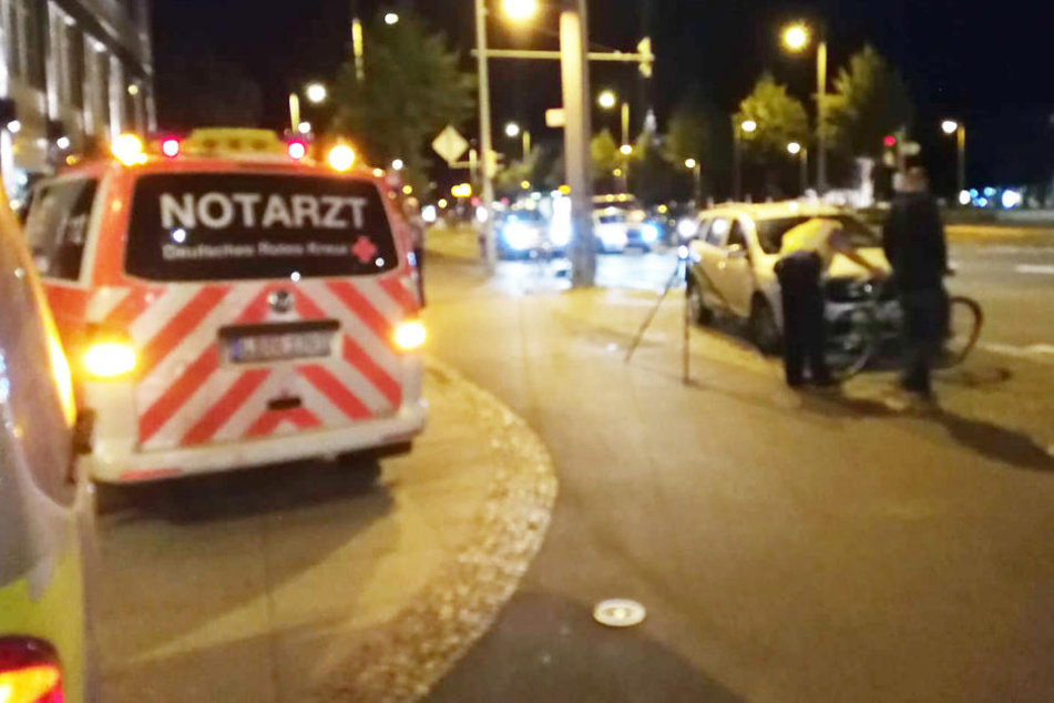 Ein Polizist begutachtet Fahrrad und Auto nach dem Unfall.