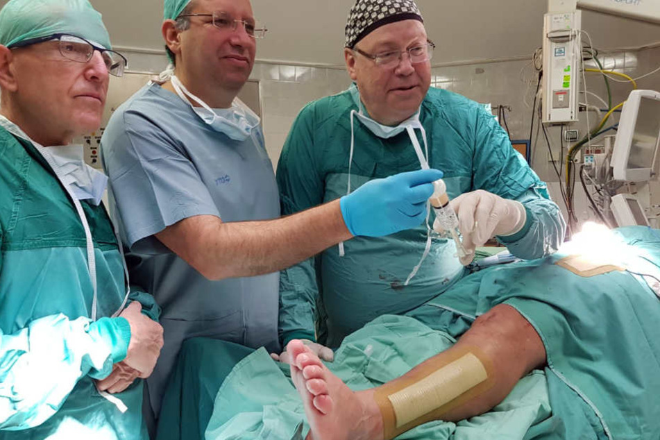 Nimrod Rosen (r), Leiter der Abteilung für Orthopädie und Rehabilitation und seine Kollegen stehen vor dem Patienten, dessen Beinbruch mit injizierbarem Knochen behandelt wurde.