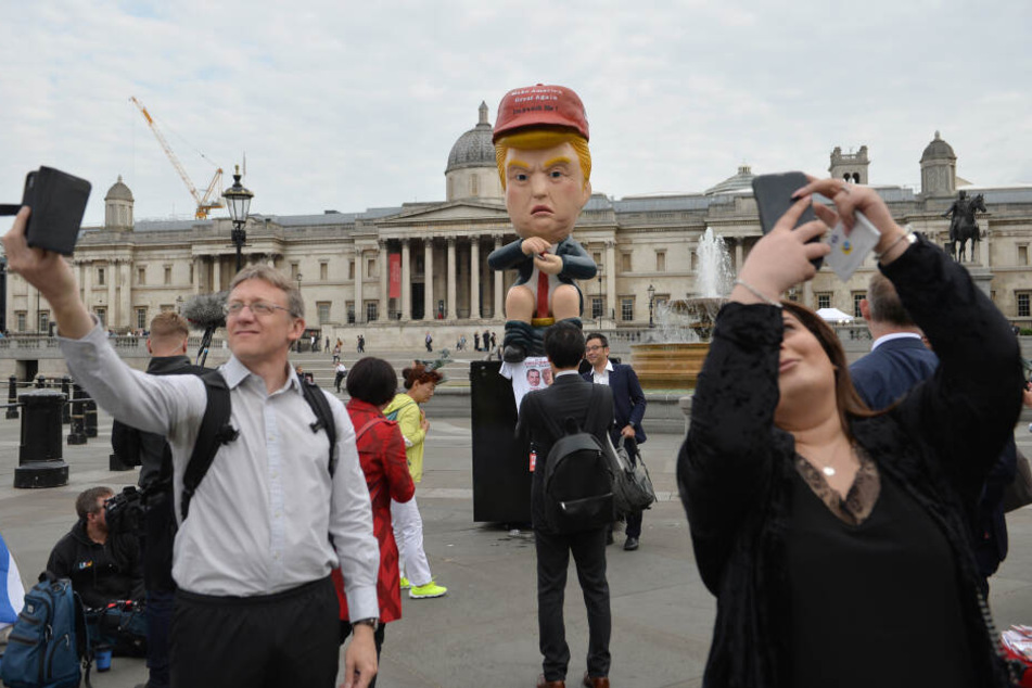Der knapp 5 Meter große sprechende Roboter im Donald-Trump-Look sitzt auf einer Goldtoilette am Trafalgar Square.