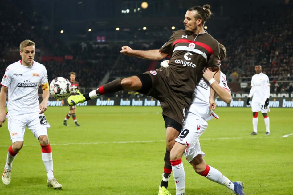 Alex Meier schirmt den Ball vor seinen Gegenspielern ab.