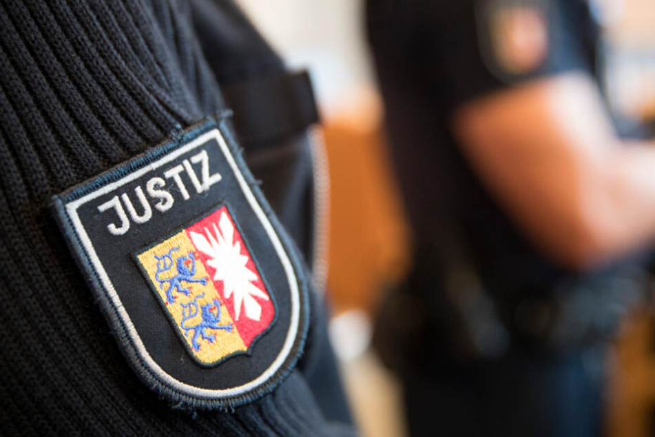 Justizbeamte stehen im Gerichtssaal. (Symbolbild)