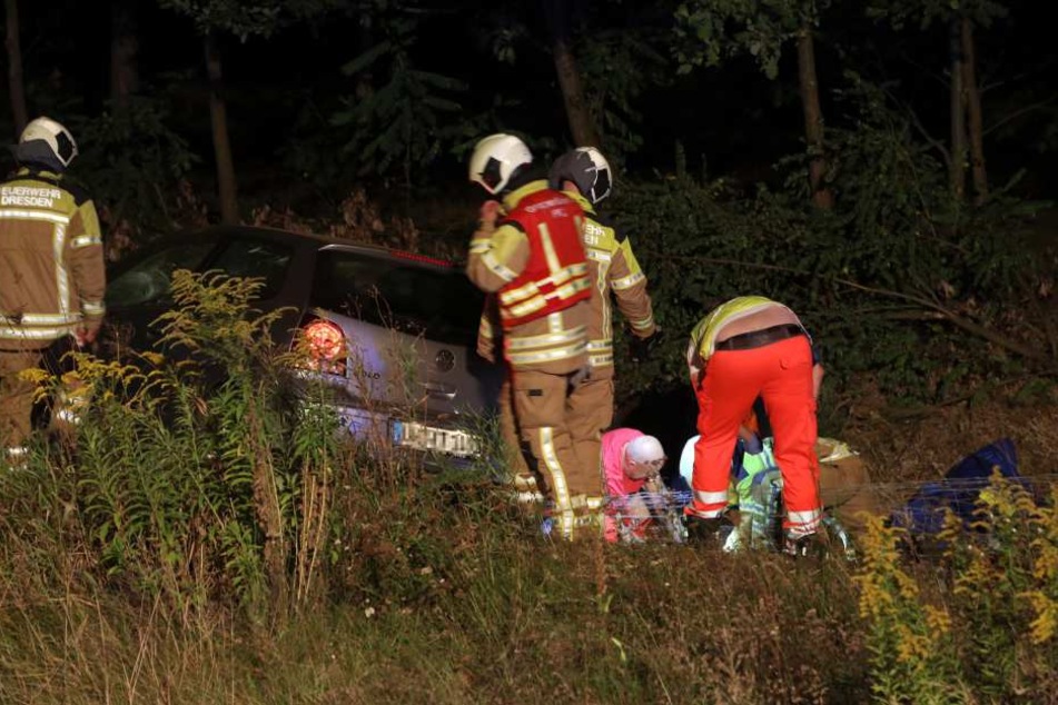 Die Rettungskräfte versorgen einen der verletzten Insassen des Autos.