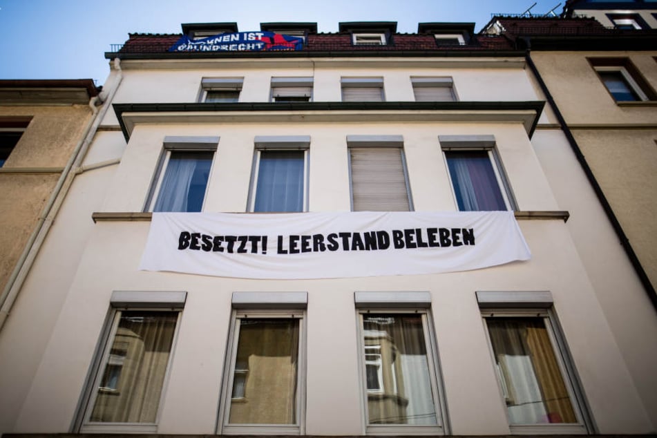 Ein Banner mit der Aufschrift "Besetzt! Leerstand beleben" hängt an einem besetzten Haus im Stuttgarter Stadtteil Heslach.